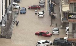 Yağmurda mahsur kalan motosikletli çareyi otomobilin üzerine çıkmakta buldu