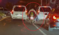 Motosiklet sürücüsü trafikte kaskı başına takması yerine arkasına bağladı