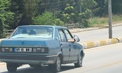 Ayaklarını camdan dışarı çıkartan yolcu trafiği riske attı