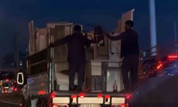 Kendi güvenliklerini değil, eşyaların güvenliğini sağlayarak kamyonetin arkasına tutundular