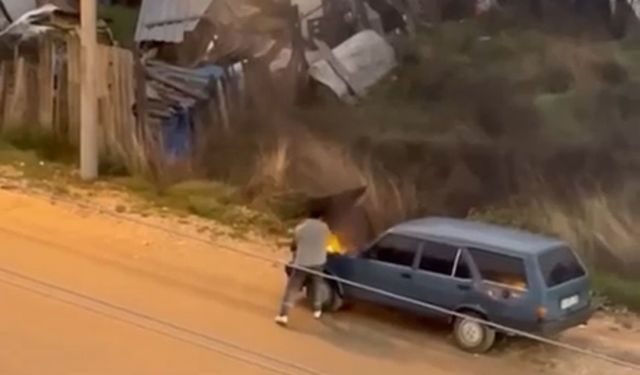 Alev alev yanan aracını kovayla su döküp söndürdü