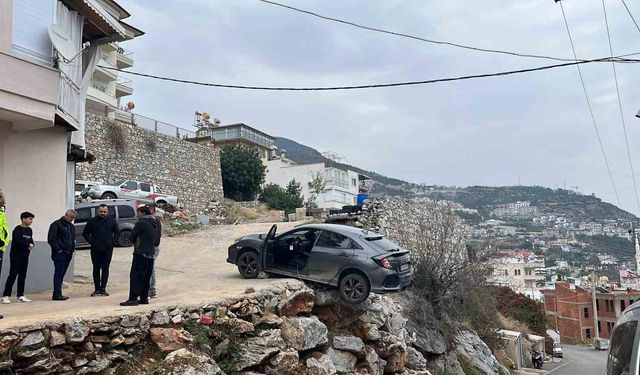 Antalya'da geri manevra yapan araç şarampolde asılı kaldı