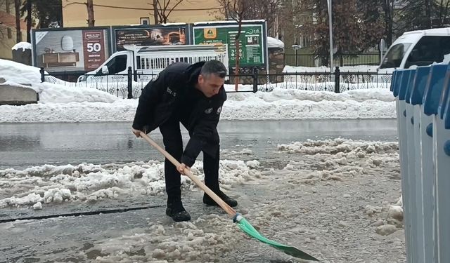Muş'ta polisten örnek davranış: Su dolan caddeyi kürekle temizledi