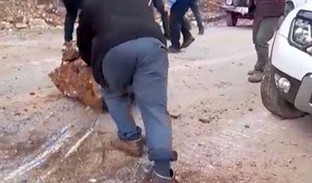 Yola düşen kayaları iple araca bağlayıp çektiler