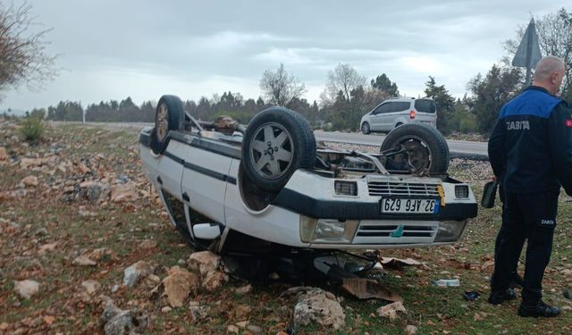Araziye devrilen otomobilden yara almadan çıktılar