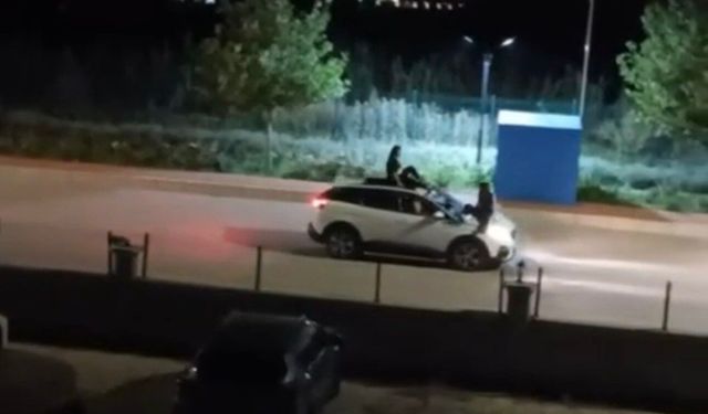 İki kadının seyir halindeki otomobilin üstünde tehlikeli yolculuğu kamerada