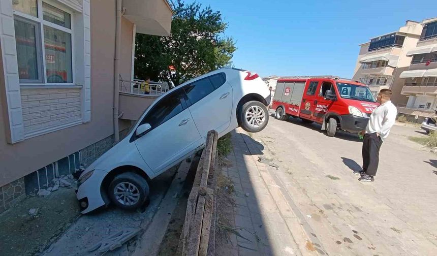 Otomobil bahçe duvarına asılı kaldı